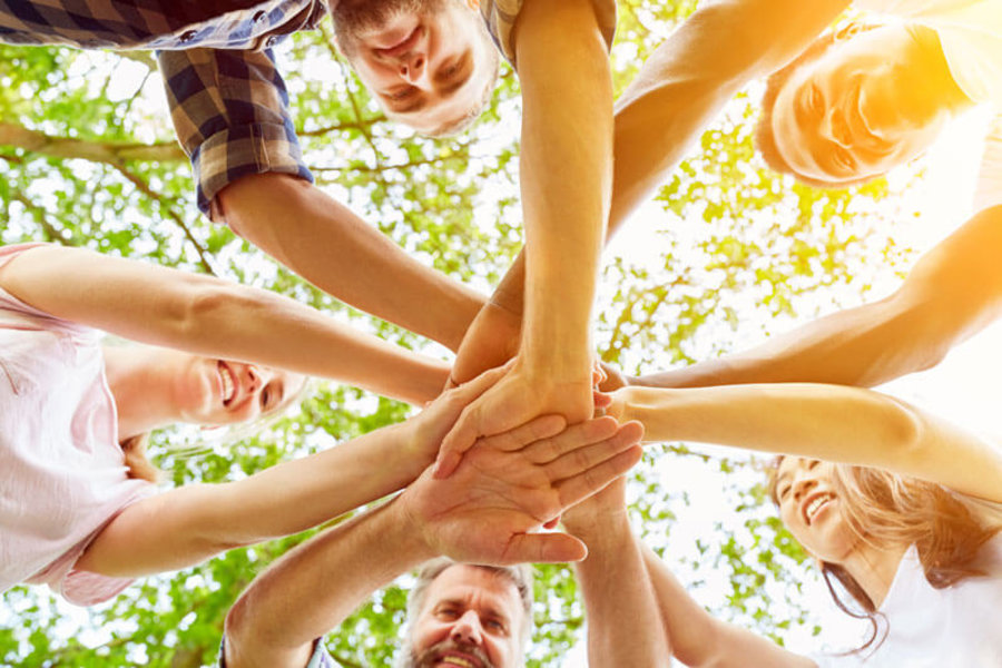 Gruppe von Menschen, die Hände zusammenhalten